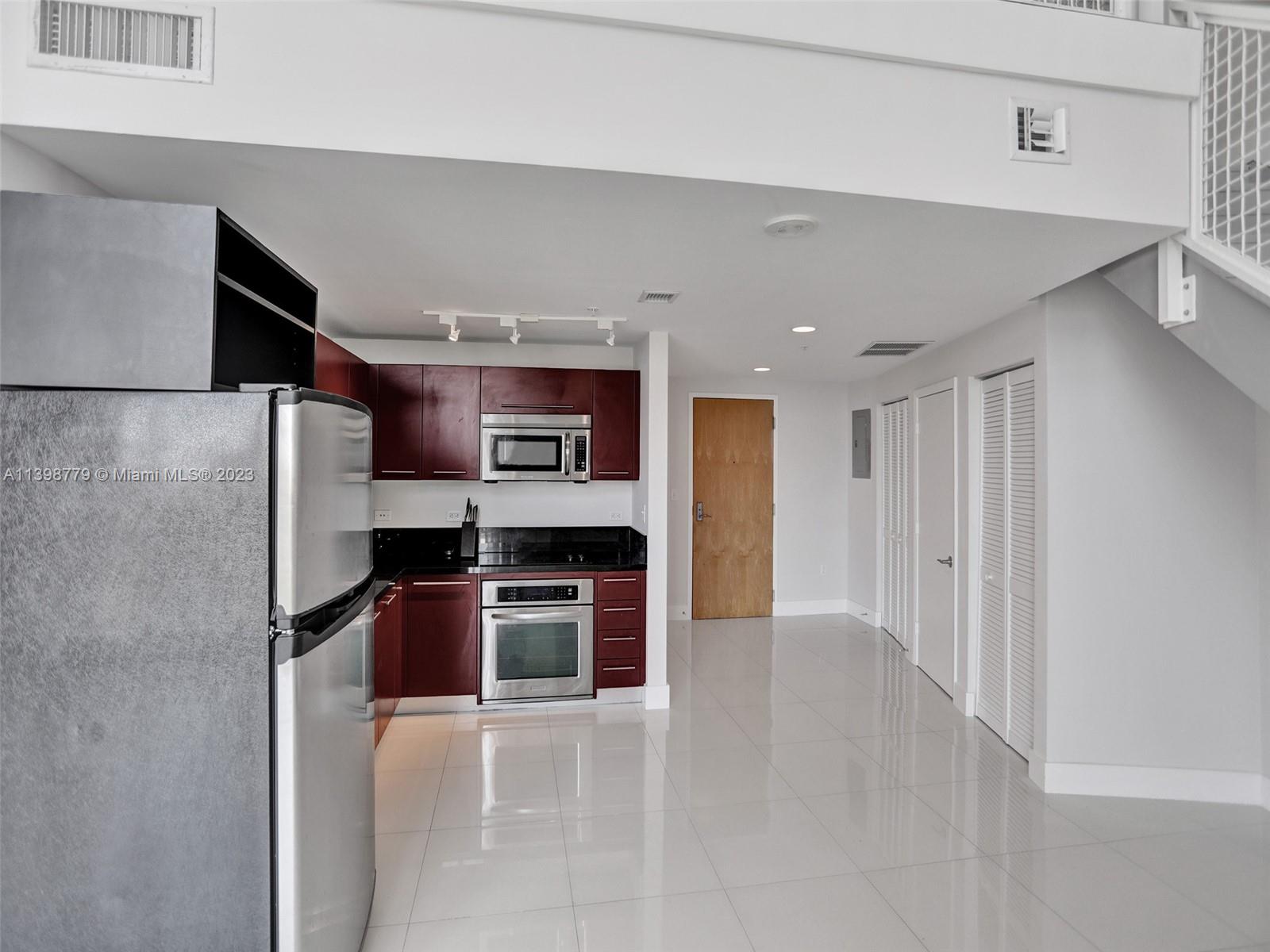 244 Biscayne Boulevard, Unit 439 Miami, FL 33132 - Photo 5 of 49 a kitchen with stainless steel appliances kitchen island granite countertop a refrigerator and a stove