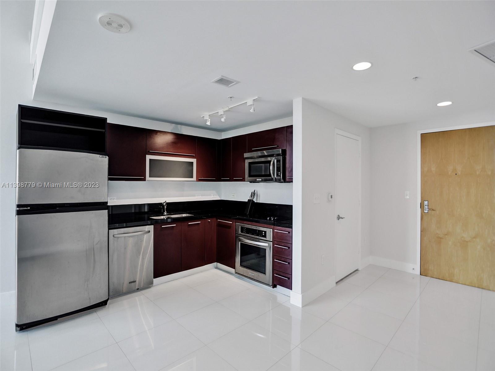 244 Biscayne Boulevard, Unit 439 Miami, FL 33132 - Photo 6 of 49 a kitchen with stainless steel appliances granite countertop a refrigerator and a stove
