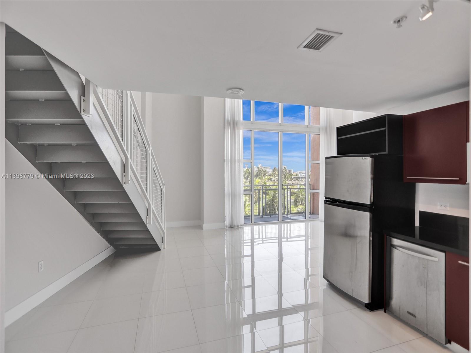 244 Biscayne Boulevard, Unit 439 Miami, FL 33132 - Photo 8 of 49 a view of kitchen with stainless steel appliances wooden floor and living room view