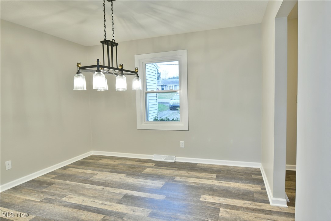 2474 Johnny Cake Road Southeast Warren, OH 44484 - Photo 20 of 50 Unfurnished dining area with baseboards, visible vents, and wood finished floors