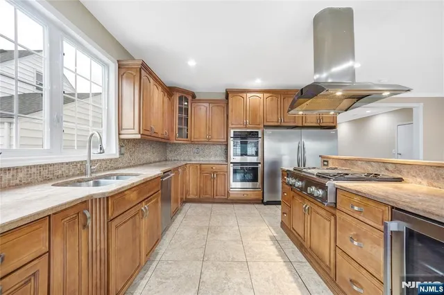 a kitchen with stainless steel appliances granite countertop a sink stove and cabinets