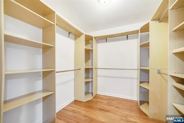 a view of walk in closet with wooden floor