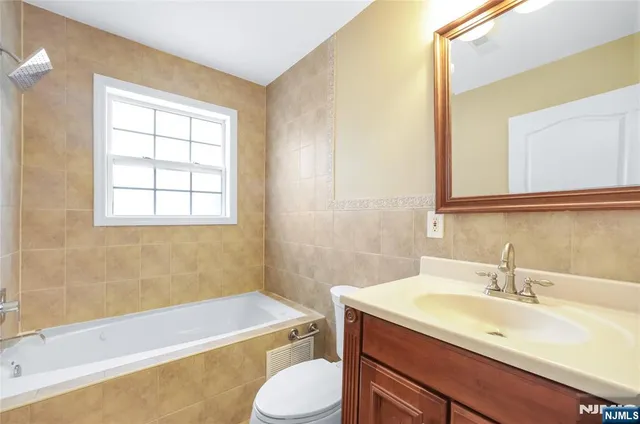 a bathroom with a sink toilet vanity and tub
