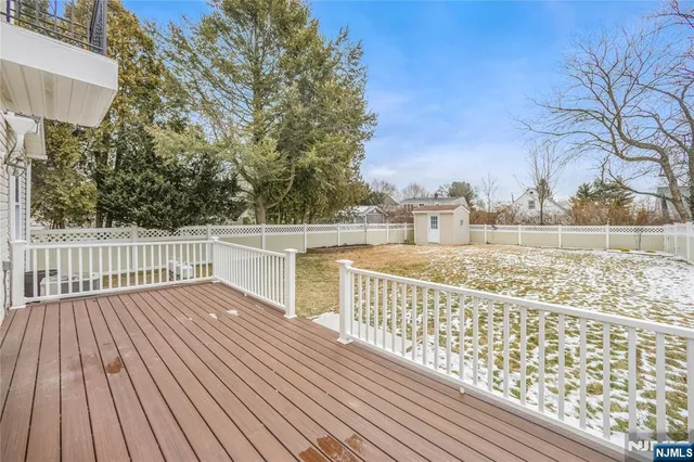 a view of deck with wooden floor and fence next to a yard