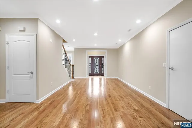 a view of empty room with wooden floor and window