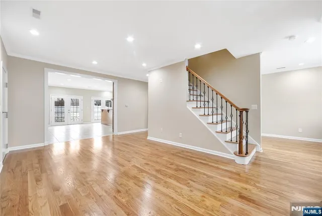 a view of a hallway with wooden floor and staircase