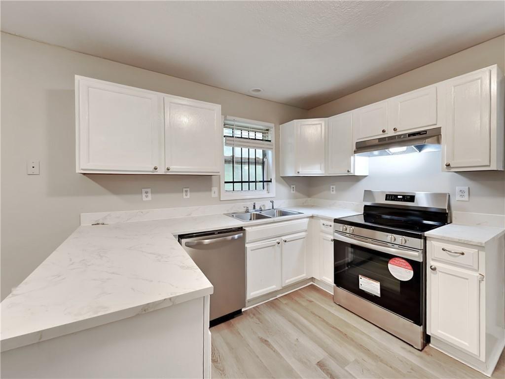 729 Cooper Street Southwest Atlanta, GA 30315 - Photo 6 of 20 a kitchen with stainless steel appliances granite countertop a stove a sink and a microwave