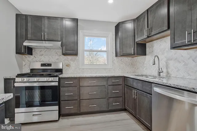 a kitchen with stainless steel appliances granite countertop a stove and a sink