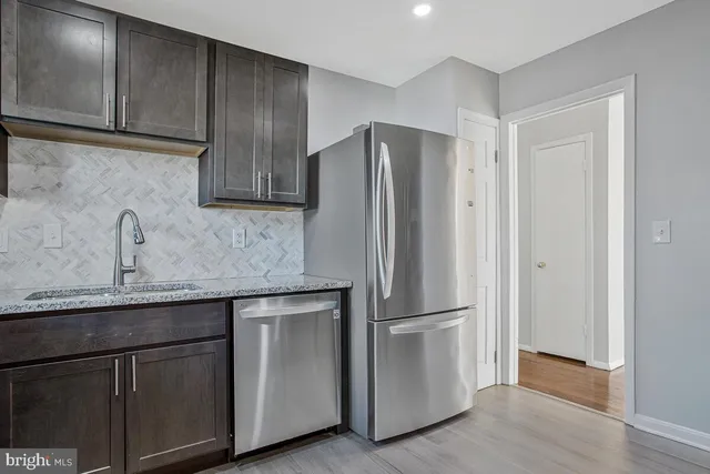 a kitchen with stainless steel appliances granite countertop a refrigerator and a sink
