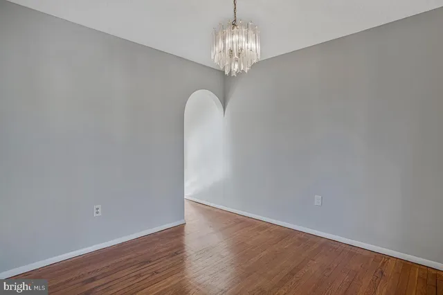 a view of a chandelier in big room and wooden floor