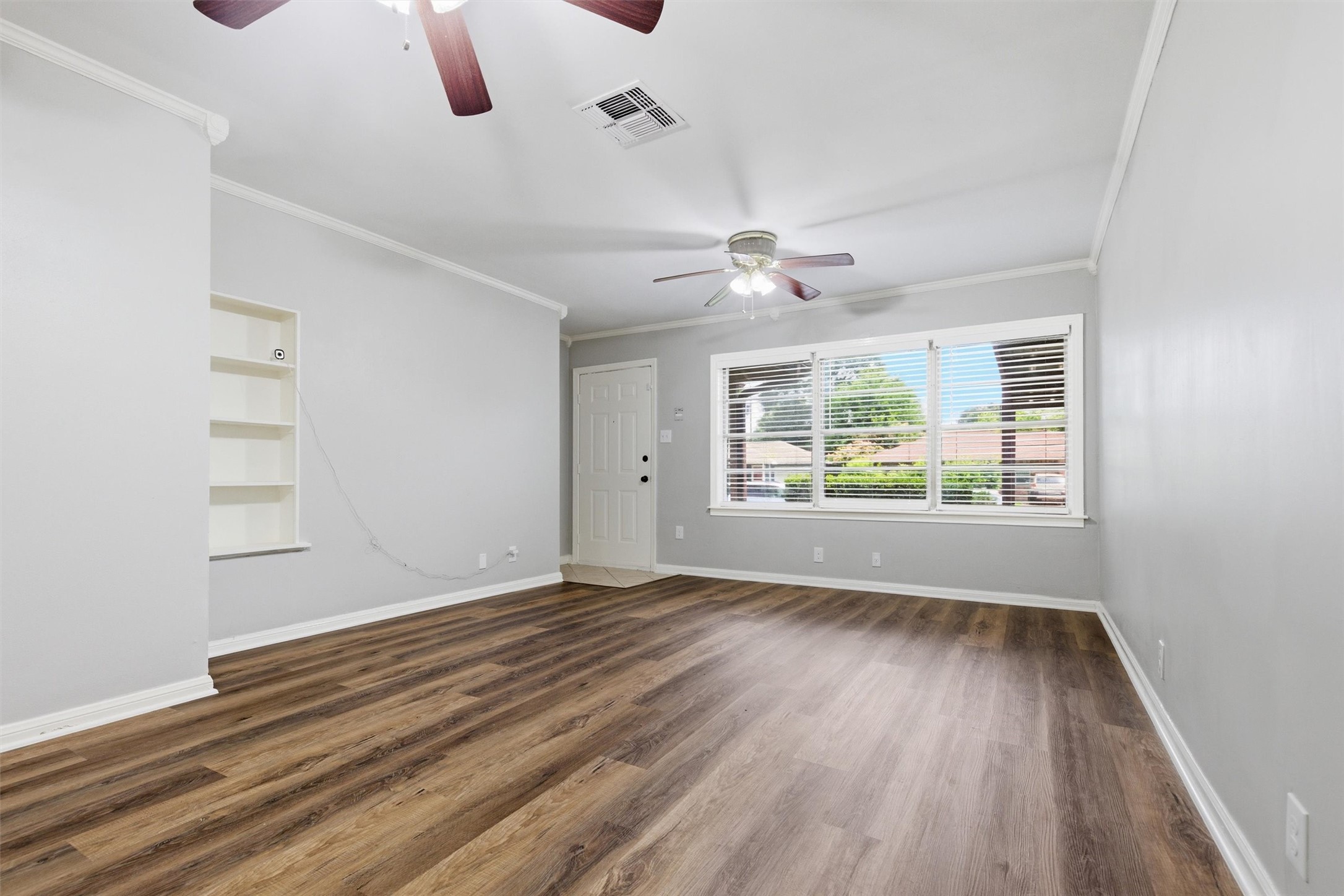 3615 Alberta Street Houston, TX 77021 - Photo 3 of 16 an empty room with wooden floor fan and windows