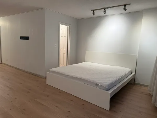 a bed sitting in a spacious bedroom next to a window