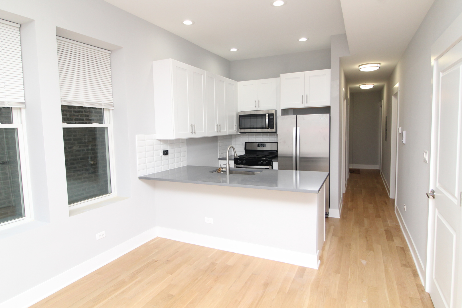 1411 West Taylor Street, Unit 2F Chicago, IL 60607 - Photo 3 of 12 a large kitchen with kitchen island a large counter top space a sink stainless steel appliances and cabinets