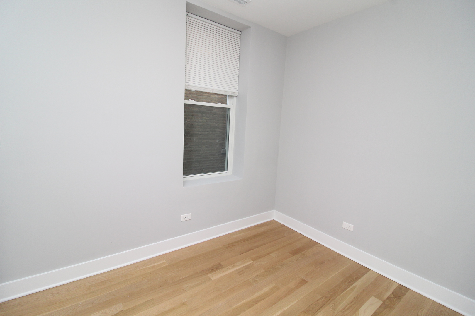 1411 West Taylor Street, Unit 2F Chicago, IL 60607 - Photo 9 of 12 a view of an empty room with wooden floor and a window