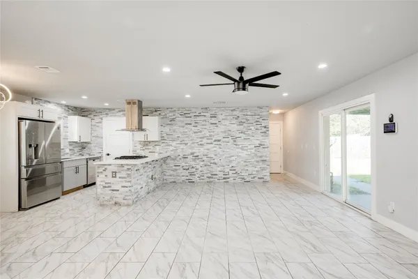 a view of a kitchen with refrigerator and wooden floor