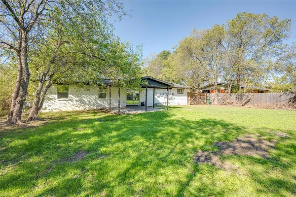 a view of a house with backyard and a tree