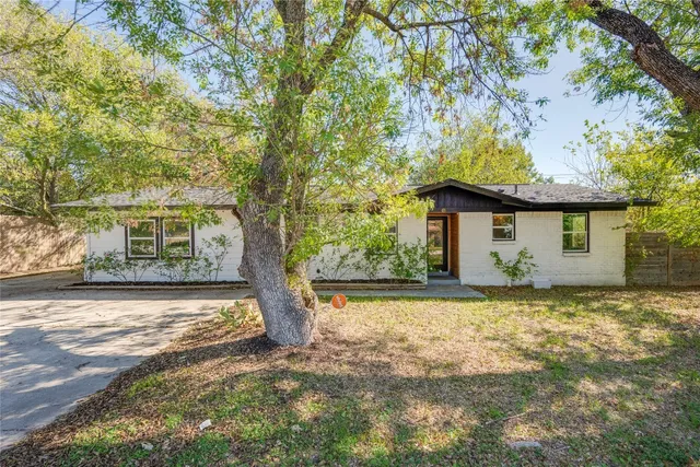 a view of a house with a tree in front of it