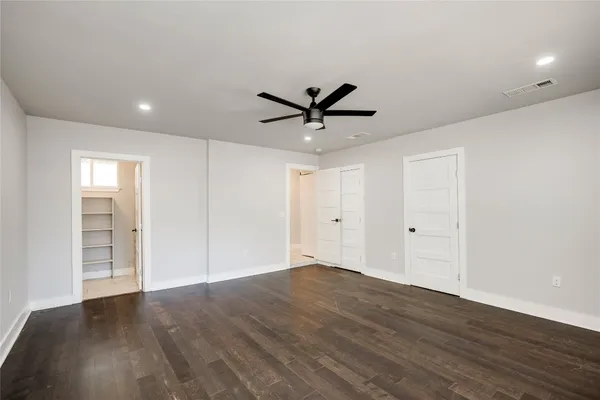 a view of a livingroom with a ceiling fan & wooden floor