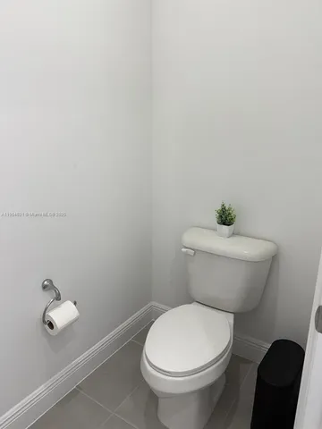 a white toilet sitting next to a white wall