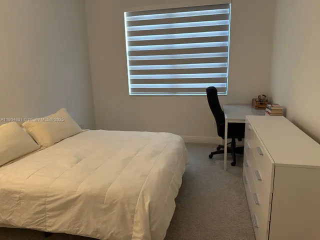 a bedroom with a bed and a desk