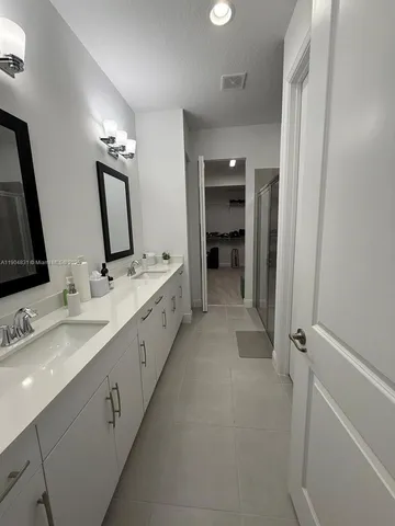 a bathroom with double vanity and a mirror