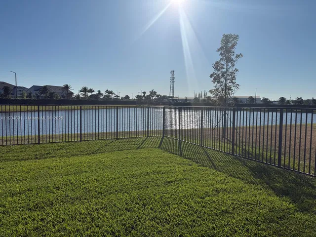 a view of a backyard with grass and wooden fence