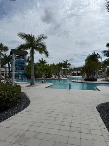 a view of swimming pool with outdoor seating and plants