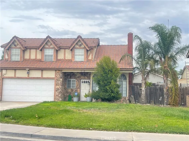 a front view of a house with a garden and plants