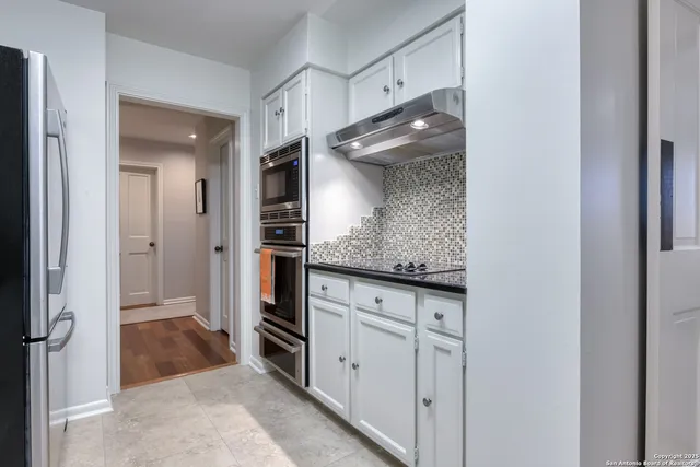 a bathroom with a granite countertop sink and a toilet