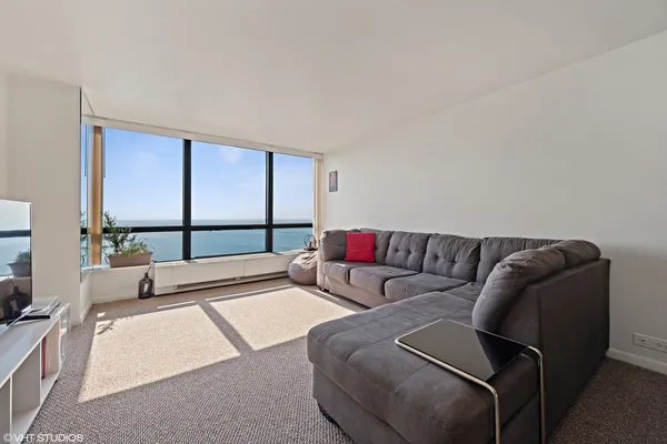 a living room with a couch a large window and a flat screen tv