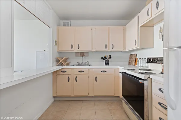 a kitchen with granite countertop white cabinets and white appliances