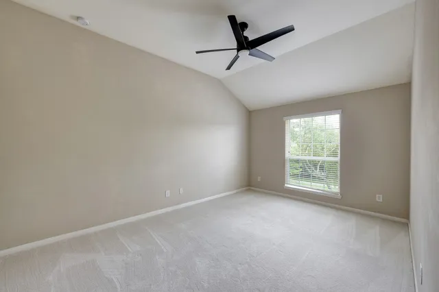 an empty room with a window and a fan
