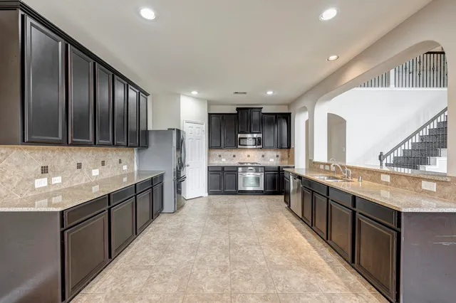 a large kitchen with stainless steel appliances lots of counter space sink and cabinets