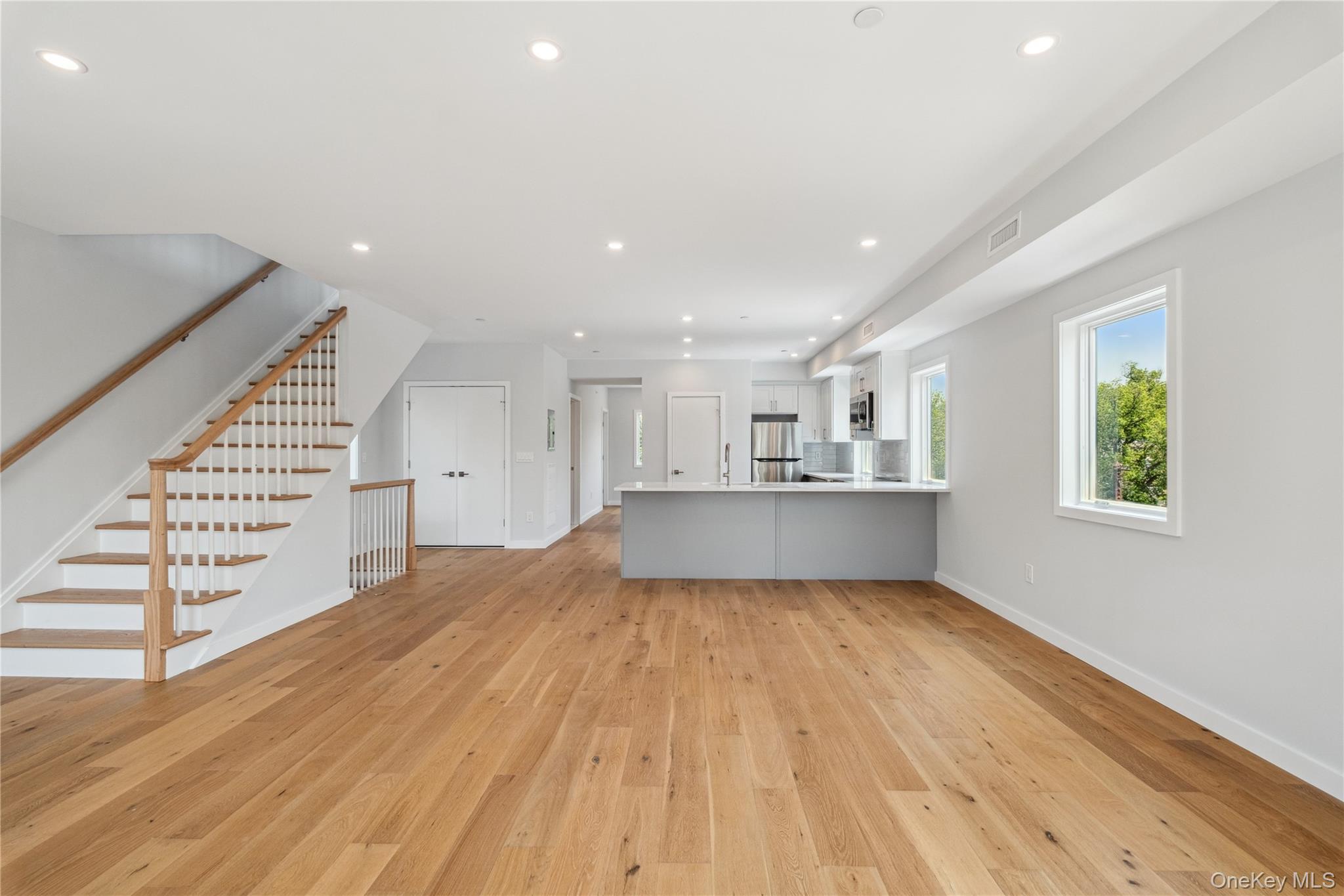 a view of a kitchen with wooden floor and staircase
