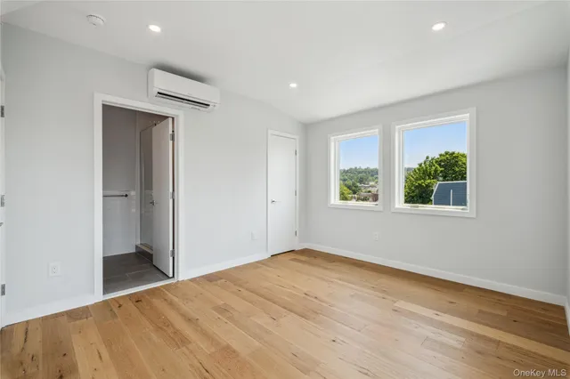 a bedroom with a balcony a bed and a large window