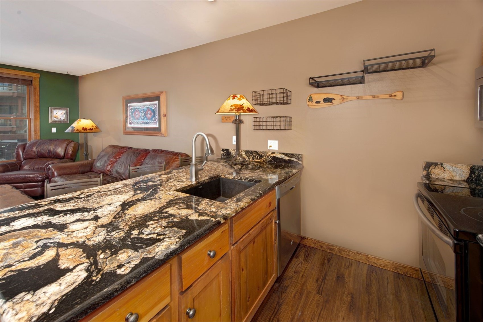 129 River Run Road, Unit 8040 Keystone, CO 80435 - Photo 11 of 50 Kitchen featuring a sink, dark wood-style flooring, electric range, dishwasher, and brown cabinetry