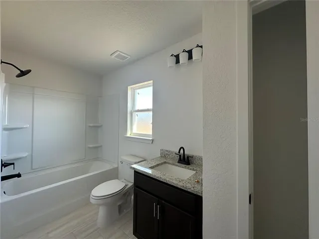 a bathroom with a granite countertop sink toilet a bathtub and shower