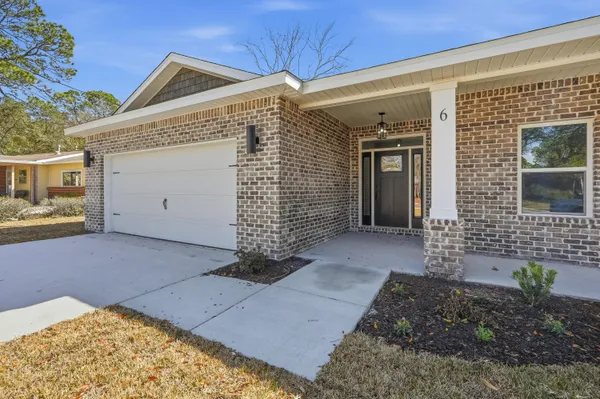 a large kitchen with stainless steel appliances kitchen island granite countertop a refrigerator a stove a sink and white cabinets with wooden floor