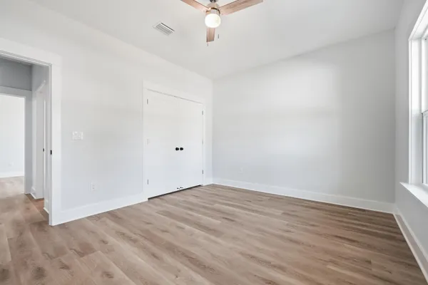 a view of an empty room with wooden floor