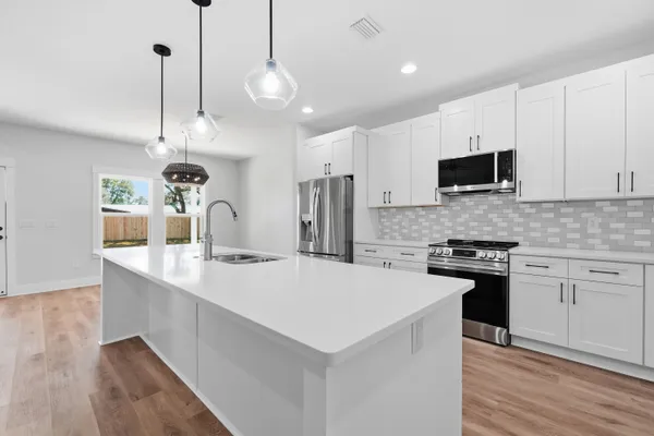 a kitchen with stainless steel appliances granite countertop a refrigerator and a stove top oven