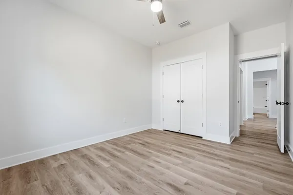 a view of a livingroom with wooden floor and a ceiling fan
