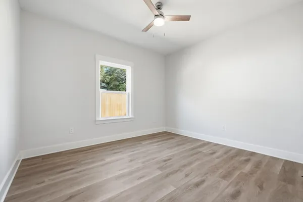 a view of kitchen with stainless steel appliances granite countertop a stove a sink refrigerator and white cabinets with wooden floor