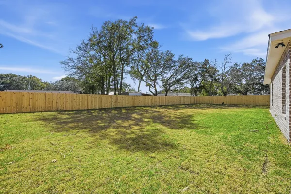 a view of backyard with wooden fence