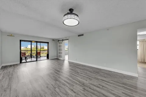 an empty room with wooden floor and ceiling fan