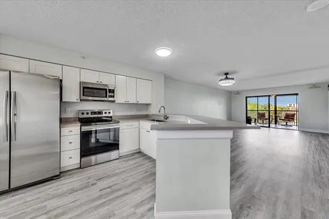 a kitchen with stove cabinets and stainless steel appliances