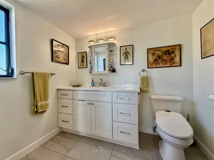 a bathroom with a granite countertop toilet sink and mirror