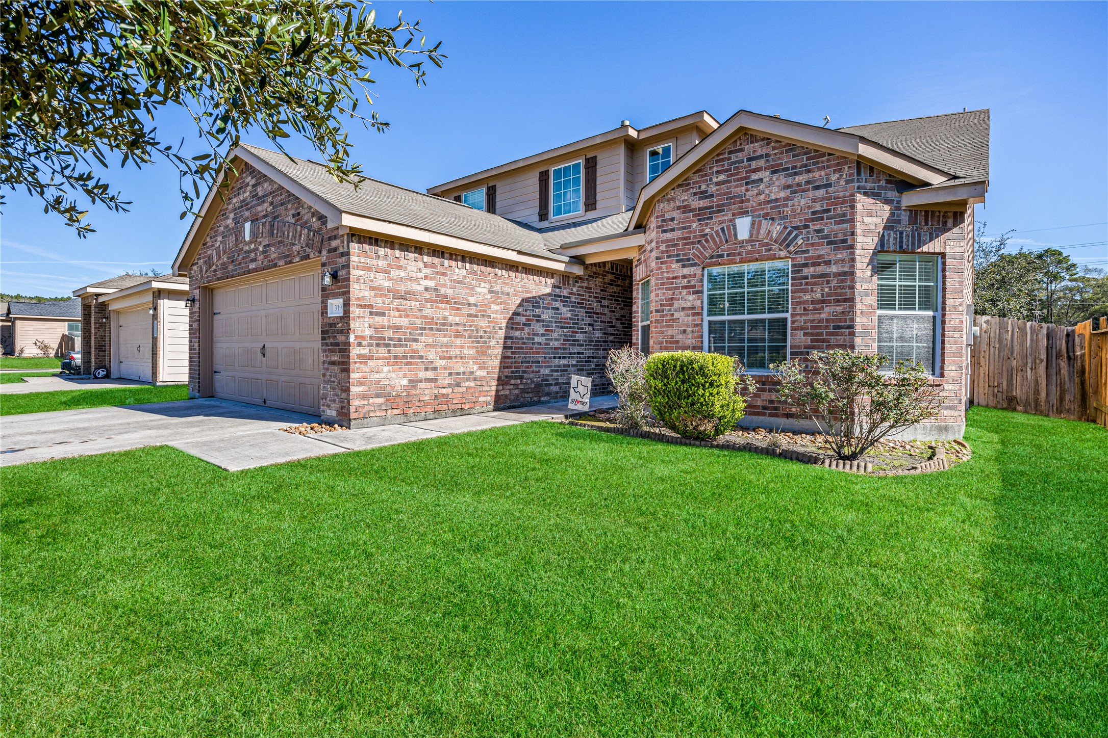 319 Falling Pine Drive Conroe, TX 77304 - Photo 1 of 22 a front view of a house with a yard and garage