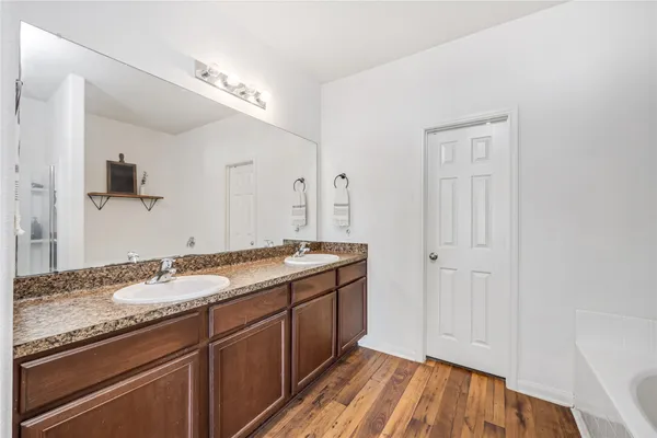 a spacious bathroom with a granite countertop sink a mirror and a shower
