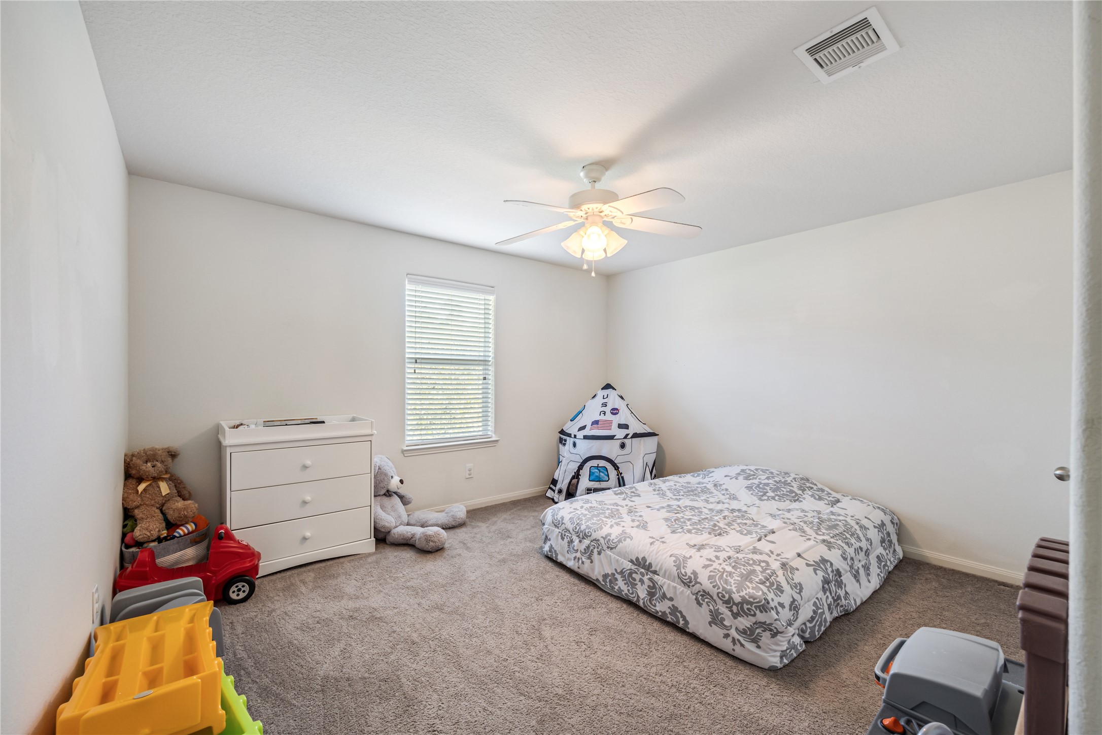 319 Falling Pine Drive Conroe, TX 77304 - Photo 19 of 22 a bedroom with a bed and a chandelier