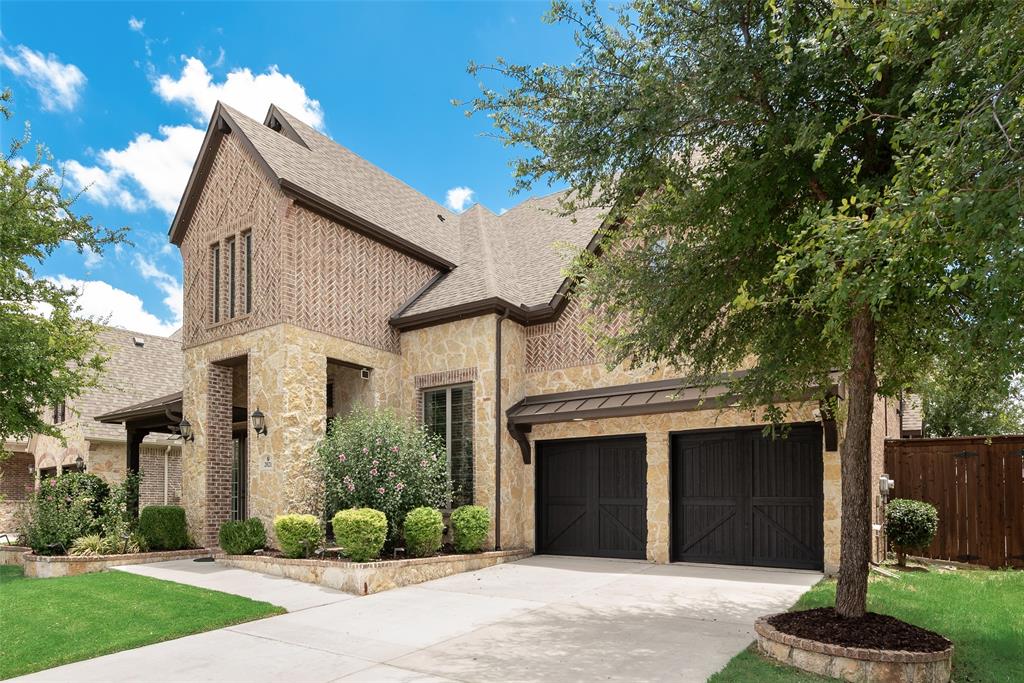 2021 Calisto Way Allen, TX 75013 - Photo 4 of 34 Two-story residence featuring a stone and brick facade, a dual-car garage with dark wood-finish doors, and a concrete driveway